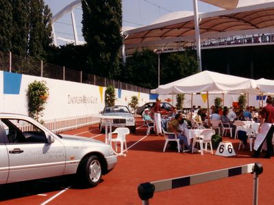 Ein Blick auf die Club-Außenanlage mit Stadion im Hintergrund und Auto mit Hürde